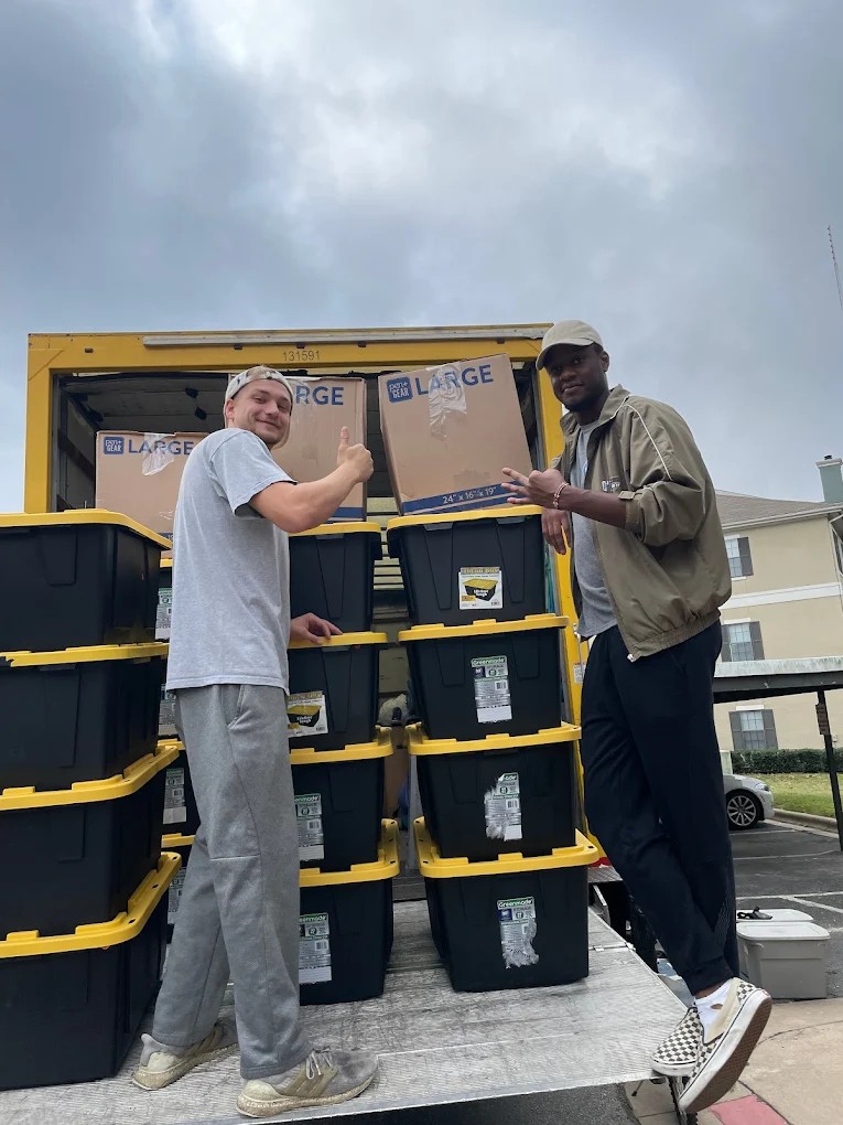 Movers loading storage bins onto the truck